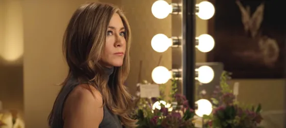 Actress Jennifer Aniston playing Alex sits down in front of a mirror ready for make up.