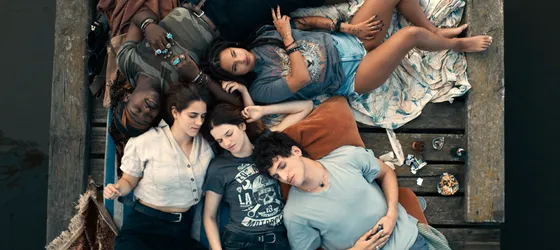 The cast members of About Sasha lying on a bridge, Paola Locatelli, Léna Garrel, Régis Marvin Merveille N’Kissi Moggzi, Angèle Metzger, Marin Judas.