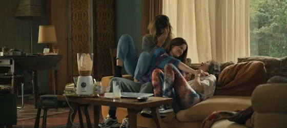 Angèle Metzger as Sasha with her mother Cécile Dalca and sister Pauline Dalca sitting down on a sofa.