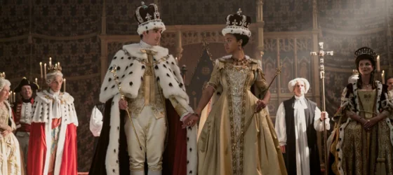 King George and Queen Charlotte in royal costumes in Queen Charlotte: A Bridgerton Story.